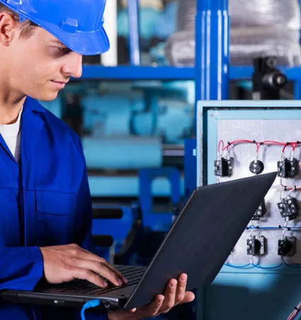 Technicien programmant un automate depuis un ordinateur portable